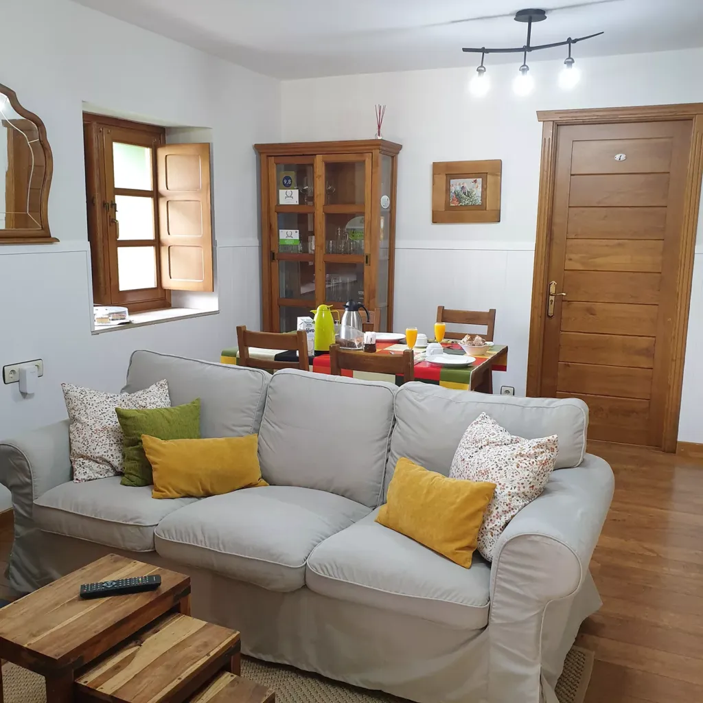 Salón con sofá y mesa de comedor con desayuno